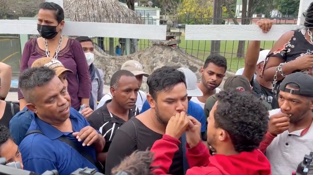 Migrantes se cosen los labios durante la mañanera; AMLO anuncia gira por Centroamérica