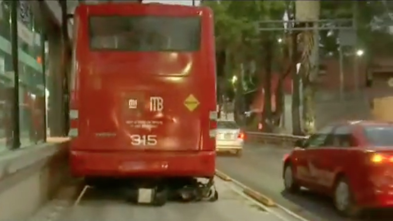 Motocicleta invade carril del Metrobús, derrapa y queda debajo de una unidad en Iztapalapa